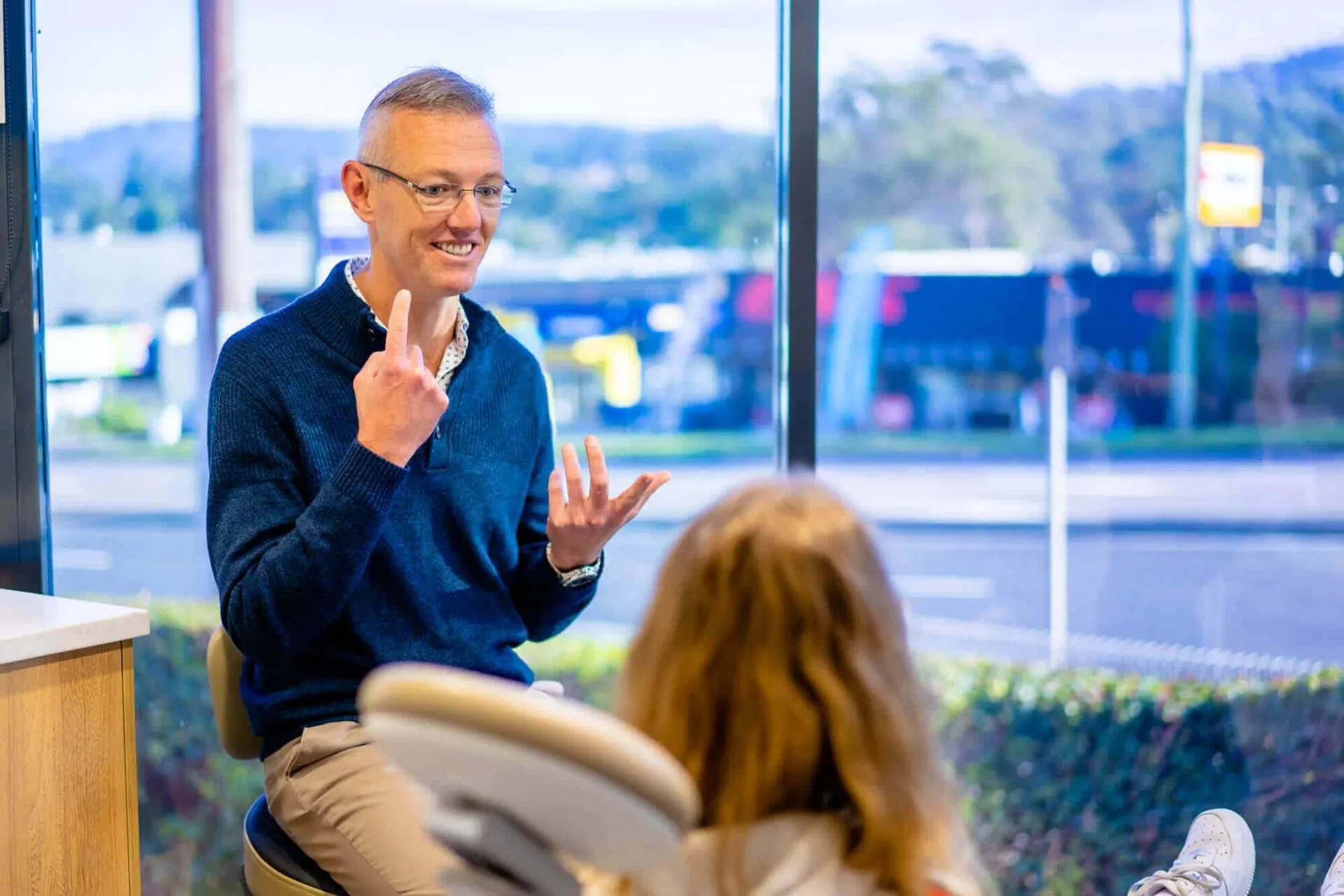 Orthodontist smiling with a young girl during a consultation at Central Coast Orthodontics
